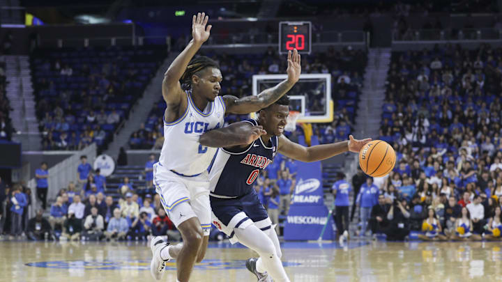 Mar 7, 2024; Los Angeles, California, USA; Arizona Wildcats guard Jaden Bradley (0) drives the ball as UCLA guard Dylan Andrews (2) defends during the second half at Pauley Pavilion presented by Wescom. Mandatory Credit: Yannick Peterhans-USA TODAY Sports