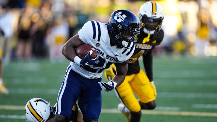 Oct 26, 2024; Laramie, Wyoming, USA; Utah State Aggies running back Rahsul Faison (3) runs against the Wyoming Cowboys during the first quarter at Jonah Field at War Memorial Stadium. Mandatory Credit: Troy Babbitt-Imagn Images