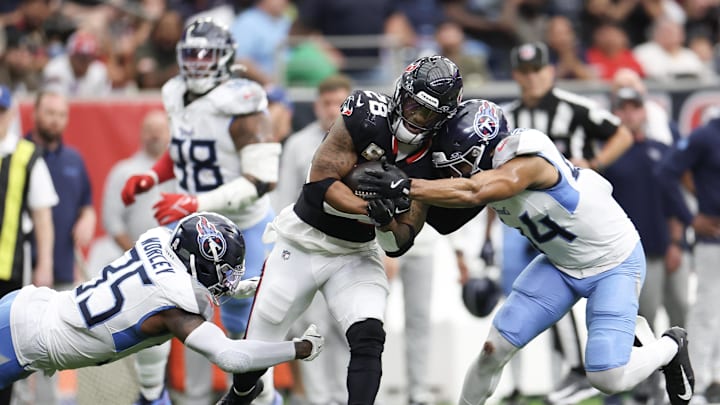 Nov 24, 2024; Houston, Texas, USA;Houston Texans running back Joe Mixon (28) is tackled by Tennessee Titans safety Mike Brown (44) in the fourth quarter at NRG Stadium. Mandatory Credit: Thomas Shea-Imagn Images