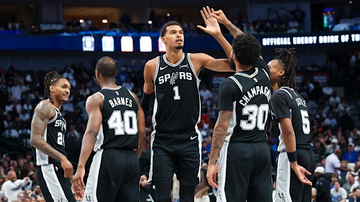 Oct 22, 2025; Dallas, Texas, USA; San Antonio Spurs forward Victor Wembanyama (1) celebrates with San Antonio Spurs forward Julian Champagnie (30) and San Antonio Spurs guard Stephon Castle (5) and San Antonio Spurs forward Harrison Barnes (40) during the second half against the Dallas Mavericks at American Airlines Center. Mandatory Credit: Kevin Jairaj-Imagn Images Oct 22, 2025; Dallas, Texas, USA; San Antonio Spurs forward Victor Wembanyama (1) celebrates with San Antonio Spurs forward Julian Champagnie (30) and San Antonio Spurs guard Stephon Castle (5) and San Antonio Spurs forward Harrison Barnes (40) during the second half against the Dallas Mavericks at American Airlines Center. Mandatory Credit: Kevin Jairaj-Imagn Images