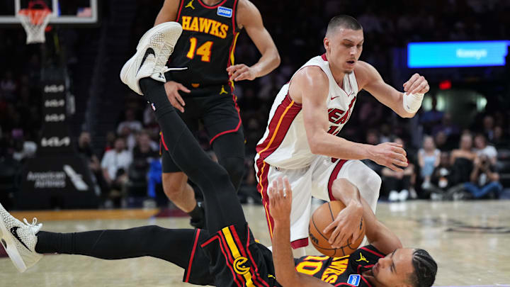 Apr 12, 2026; Miami, Florida, USA;  Atlanta Hawks forward Zaccharie Risacher (10) and Miami Heat guard Tyler Herro (14) battle for the ball during the first half at Kaseya Center. Mandatory Credit: Jim Rassol-Imagn Images