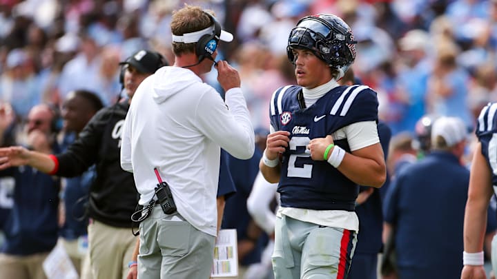 Oct 26, 2024; Oxford, Mississippi, USA; Mississippi Rebels head coach Lane Kiffin (left) talks with quarterback Jaxson Dart (2) during a time out during the second half against the Oklahoma Sooners at Vaught-Hemingway Stadium. Mandatory Credit: Petre Thomas-Imagn Images