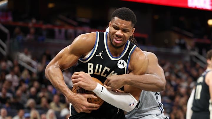 Jan 10, 2025; Orlando, Florida, USA; Milwaukee Bucks forward Giannis Antetokounmpo (34) and Orlando Magic center Wendell Carter Jr. (34) fight for a loose ball in the fourth quarter at Kia Center. Mandatory Credit: Nathan Ray Seebeck-Imagn Images