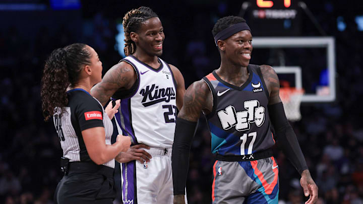 Apr 7, 2024; Brooklyn, New York, USA; Brooklyn Nets guard Dennis Schroder (17) and Sacramento Kings guard Keon Ellis (23) talks with referee Sha’Rae Mitchell (98) during the first quarter at Barclays Center. Mandatory Credit: Vincent Carchietta-Imagn Images
