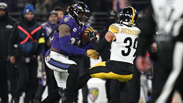 Jan 11, 2025; Baltimore, Maryland, USA; Baltimore Ravens running back Derrick Henry (22) runs against Pittsburgh Steelers safety Minkah Fitzpatrick (39) in the second quarter in an AFC wild card game at M&T Bank Stadium. Mandatory Credit: Tommy Gilligan-Imagn Images