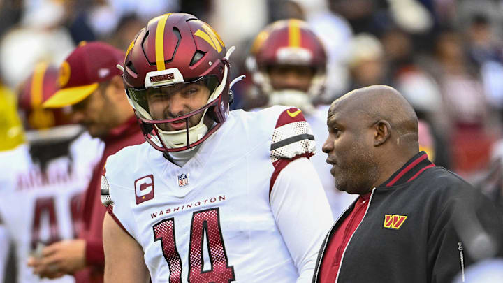 Jan 7, 2024; Landover, Maryland, USA; Washington Commanders quarterback Sam Howell (14) talks with Washington Commanders offensive coordinator Eric Bieniemy before the game against the Dallas Cowboys at FedExField. Mandatory Credit: Brad Mills-Imagn Images