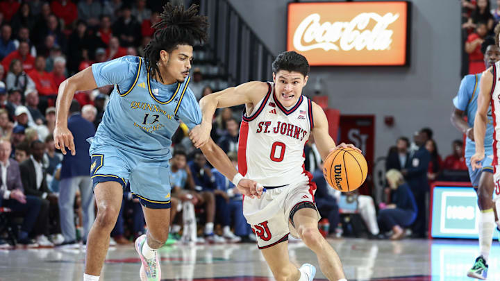 Nov 3, 2025; Queens, New York, USA; St. John's basketball guard Dylan Darling (0) drives past Quinnipiac Bobcats forward Braylan Ritvo (13) in the second half at Carnesecca Arena. Nov 3, 2025; Queens, New York, USA; St. John's basketball guard Dylan Darling (0) drives past Quinnipiac Bobcats forward Braylan Ritvo (13) in the second half at Carnesecca Arena.