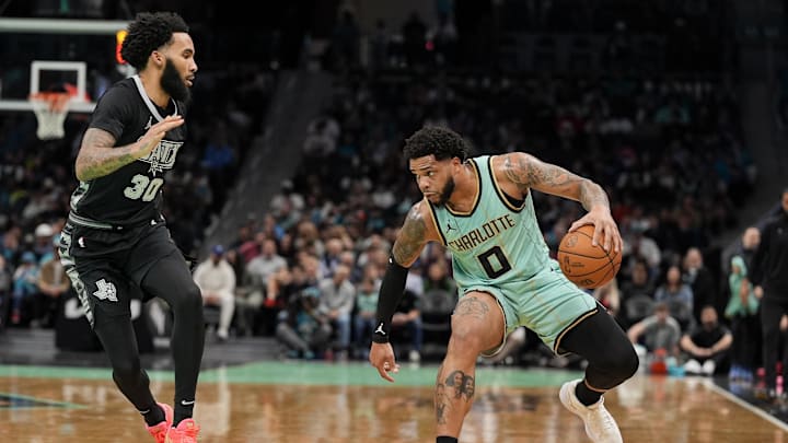 Charlotte Hornets forward Miles Bridges handles the ball defended by San Antonio Spurs forward Julian Champagnie during the first quarter at Spectrum Center.
