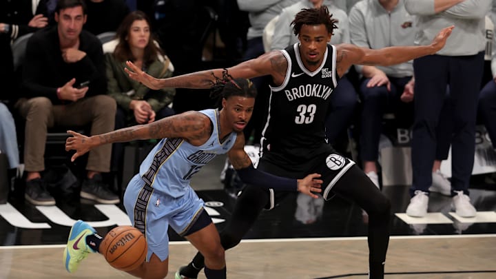 Nov 4, 2024; Brooklyn, New York, USA; Memphis Grizzlies guard Ja Morant (12) fights for the ball against Brooklyn Nets center Nic Claxton (33) during the fourth quarter at Barclays Center. Mandatory Credit: Brad Penner-Imagn Images