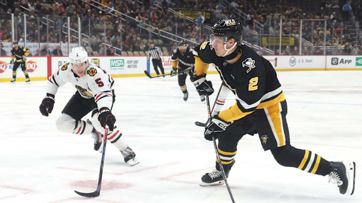 Apr 8, 2025; Pittsburgh, Pennsylvania, USA;  Pittsburgh Penguins right wing Rutger McGroarty (2) shoots the puck as Chicago Blackhawks defenseman Connor Murphy (5) defends during the first period at PPG Paints Arena. Mandatory Credit: Charles LeClaire-Imagn Images