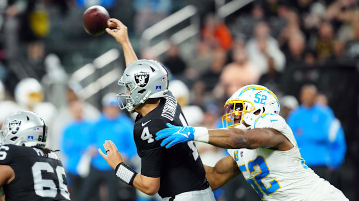 Dec 14, 2023; Paradise, Nevada, USA; Las Vegas Raiders quarterback Aidan O'Connell (4) throws under pressure from Los Angeles Chargers linebacker Khalil Mack (52) in the second quarter at Allegiant Stadium. Mandatory Credit: Stephen R. Sylvanie-Imagn Images