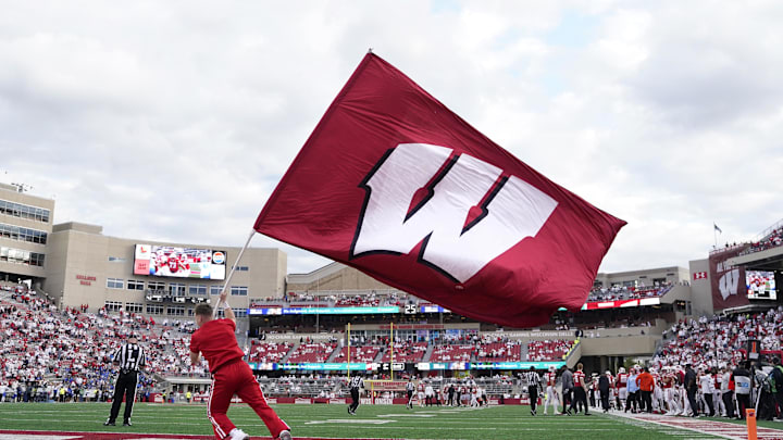 Sep 6, 2025; Madison, Wisconsin, USA; A Wisconsin Badgers cheerleader waves a Wisconsin flag after the team scores a touchdown against the Middle Tennessee Blue Raiders during the second half at Camp Randall Stadium. Mandatory Credit: Kayla Wolf-Imagn Images