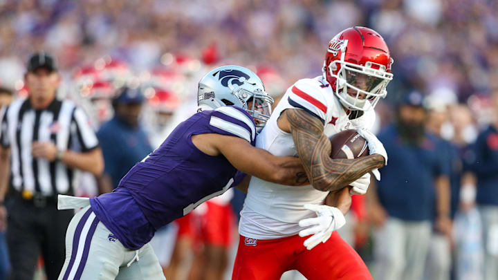 Sep 13, 2024; Manhattan, Kansas, USA; Arizona Wildcats wide receiver Tetairoa McMillan (4) is tackled by Kansas State Wildcats cornerback Keenan Garber (1) during the first quarter at Bill Snyder Family Football Stadium. Mandatory Credit: Scott Sewell-Imagn Images