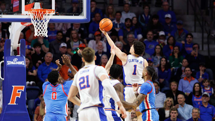 Mar 8, 2025; Gainesville, Florida, USA; Florida Gators guard Walter Clayton Jr. (1) makes a layup over Mississippi Rebels forward Malik Dia (0) during the first half at Exactech Arena at the Stephen C. O'Connell Center. Mandatory Credit: Matt Pendleton-Imagn Images