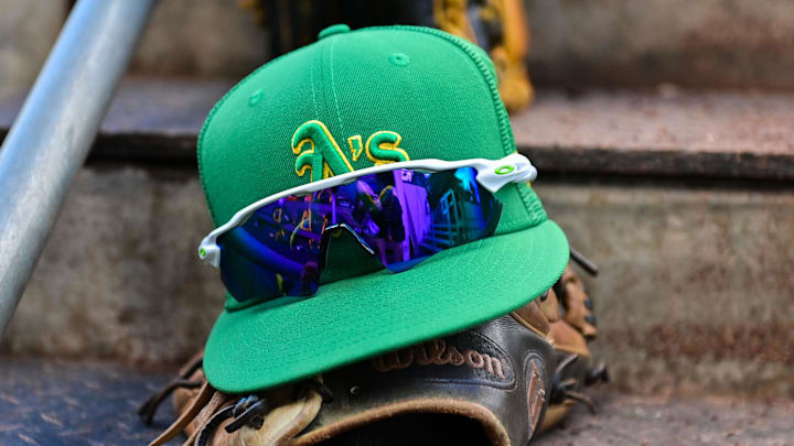 Mar 2, 2023; Mesa, Arizona, USA; General view of an Oakland Athletics hat, glove glasses prior to a Spring Training game against the Chicago Cubs at Sloan Park. Mandatory Credit: Matt Kartozian-Imagn Images