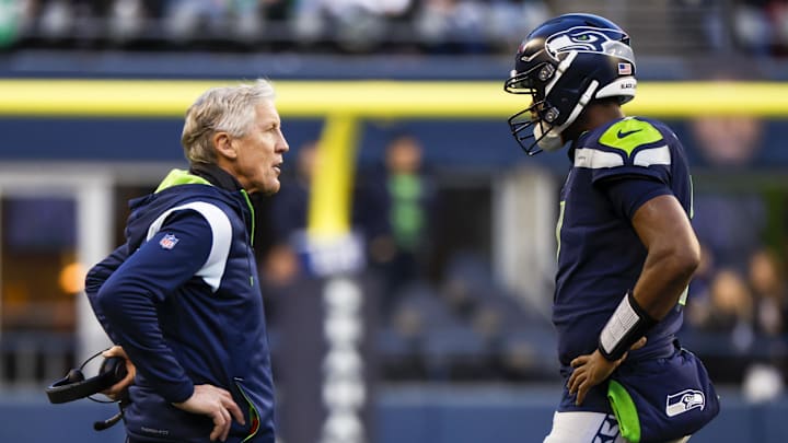 Jan 1, 2023; Seattle, Washington, USA; Seattle Seahawks head coach Pete Carroll, left, talks with quarterback Geno Smith (7) during a fourth quarter timeout against the New York Jets at Lumen Field. Mandatory Credit: Joe Nicholson-Imagn Images