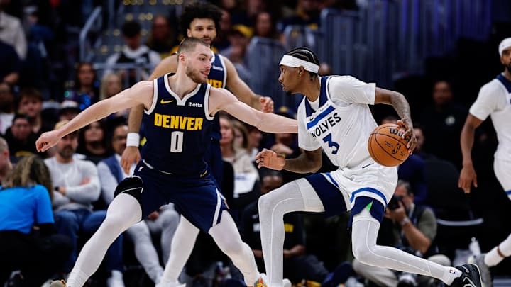 Apr 27, 2026; Denver, Colorado, USA; Minnesota Timberwolves forward Jaden McDaniels (3) controls the ball as Denver Nuggets guard Christian Braun (0) guards in the third quarter during game five of the first round of the 2026 NBA Playoffs at Ball Arena. Mandatory Credit: Isaiah J. Downing-Imagn Images