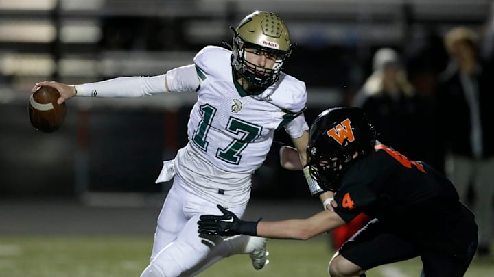Oshkosh North quarterback Bryce Ott (17) fights off a West De Pere defender during a first-round WIAA Division 2 playoff game on Oct. 25, 2024.