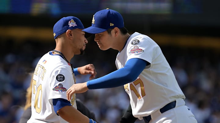 Mar 27, 2025; Los Angeles, California, USA; Los Angeles Dodgers shortstop Mookie Betts (50) and two-way player Shohei Ohtani (17) react before the game against the Detroit Tigers at Dodger Stadium. Mandatory Credit: Jayne Kamin-Oncea-Imagn Images