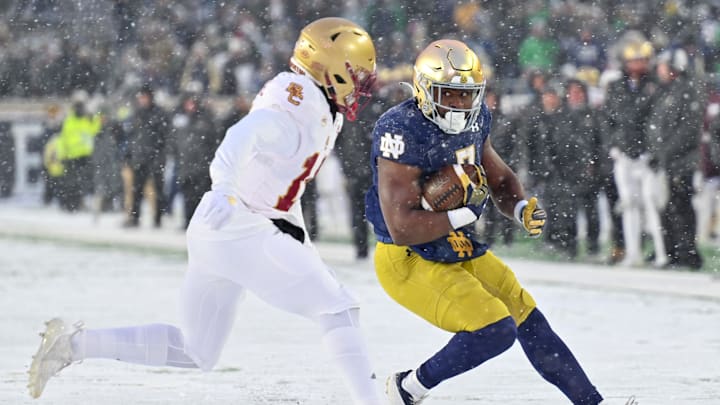 Nov 19, 2022; South Bend, Indiana, USA; Notre Dame Fighting Irish running back Audric Estime (7) runs the ball as Boston College Eagles cornerback Jalon Williams (14) defends in the fourth quarter at Notre Dame Stadium. Mandatory Credit: Matt Cashore-Imagn Images