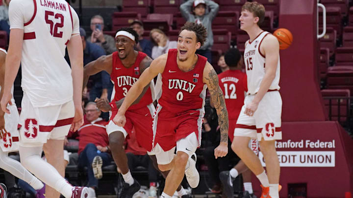 Dec 7, 2025; Stanford, California, USA;  UNLV Runnin' Rebels guard Dra Gibbs-Lawhorn (0) and center Emmanuel Stephen (34) celebrates after the buzzer sounds as Stanford Cardinal forward/center Aidan Cammann (52) and Stanford Cardinal forward/center Oskar Giltay (15) look on in the second half at Maples Pavilion. Mandatory Credit: David Gonzales-Imagn Images