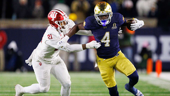 Notre Dame running back Jeremiyah Love (4) runs the ball past Indiana linebacker Rolijah Hardy (21) during the first round of the College Football Playoff between Notre Dame and Indiana at Notre Dame Stadium on Friday, Dec. 20, 2024, in South Bend.