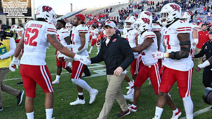 Wisconsin Badgers interim head coach Jim Leonhard is congratulated by Wisconsin Badgers players after earning his first win against the Northwestern Wildcats at Ryan Field. 