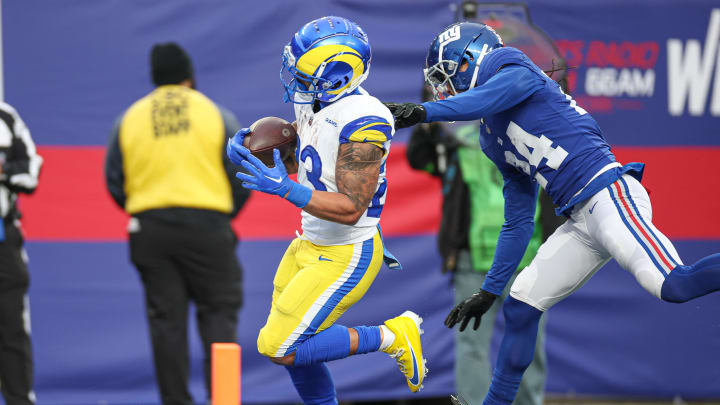 Dec 31, 2023; East Rutherford, New Jersey, USA; Los Angeles Rams running back Kyren Williams (23) scores a rushing touchdown during the second half in front of New York Giants safety Dane Belton (24) at MetLife Stadium. Mandatory Credit: Vincent Carchietta-USA TODAY Sports