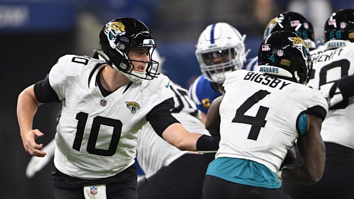 Jan 5, 2025; Indianapolis, Indiana, USA; Jacksonville Jaguars quarterback Mac Jones (10) hands then all off to Jacksonville Jaguars running back Tank Bigsby (4) during the second half against the Indianapolis Colts at Lucas Oil Stadium. Mandatory Credit: Marc Lebryk-Imagn Images