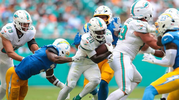 Miami Dolphins running back De'Von Achane (28) carries the football against Los Angeles Chargers free safety Derwin James (3) during the second quarter at Hard Rock Stadium. Miami Dolphins running back De'Von Achane (28) carries the football against Los Angeles Chargers free safety Derwin James (3) during the second quarter at Hard Rock Stadium.