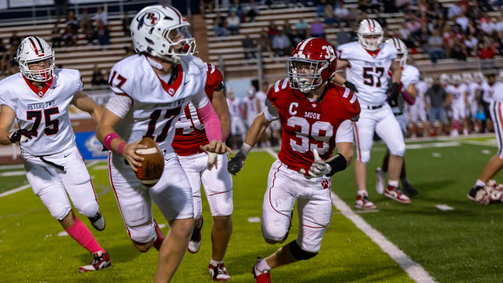 Moon Area senior linebacker Tavis Lindsay (39) pursues Peters Township junior quarterback Nolan DiLuca (17) during Moon Area's Allegheny Six matchup against Peters Township Friday night at Tiger Stadium. Moon Area senior linebacker Tavis Lindsay (39) pursues Peters Township junior quarterback Nolan DiLuca (17) during Moon Area's Allegheny Six matchup against Peters Township Friday night at Tiger Stadium.