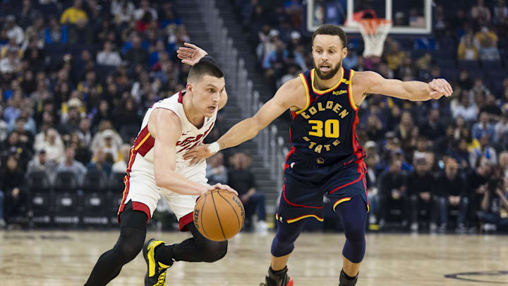 Jan 7, 2025; San Francisco, California, USA; Miami Heat guard Tyler Herro (14) drives past Golden State Warriors guard Stephen Curry (30) during the first quarter at Chase Center. Mandatory Credit: John Hefti-Imagn Images