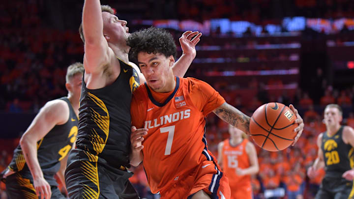Feb 25, 2025; Champaign, Illinois, USA;  Illinois Fighting Illini forward Will Riley (7) drives the ball against Iowa Hawkeyes guard Carter Kingsbury (14) during the first half at State Farm Center. Mandatory Credit: Ron Johnson-Imagn Images