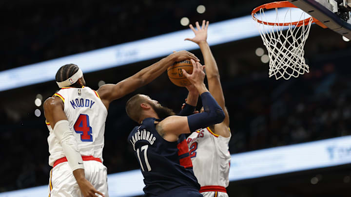 Nov 4, 2024; Washington, District of Columbia, USA; Washington Wizards center Jonas Valanciunas (17) attempts to shoot the ball as Golden State Warriors guard Moses Moody (4) and Warriors forward Trayce Jackson-Davis (32) defend in the first half at Capital One Arena. Mandatory Credit: Geoff Burke-Imagn Images