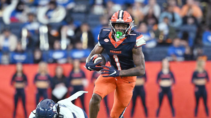 Nov 23, 2024; Syracuse, New York, USA; Syracuse Orange running back LeQuint Allen (1) avoids a tackle by Connecticut Huskies linebacker Jayden McDonald (10) in the first quarter at the JMA Wireless Dome. Mandatory Credit: Mark Konezny-Imagn Images