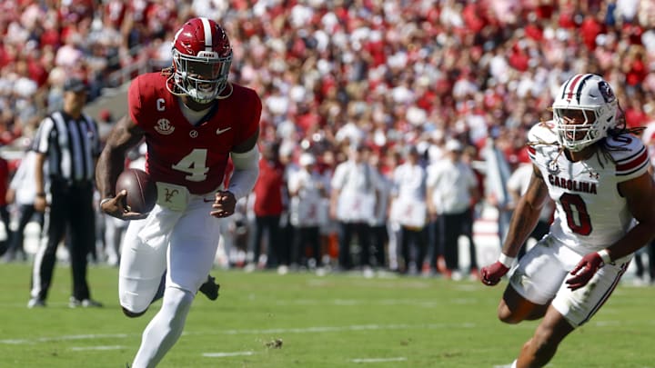 Oct 12, 2024; Tuscaloosa, Alabama, USA;  Alabama Crimson Tide quarterback Jalen Milroe (4) carries the ball in for a touchdown as South Carolina Gamecocks linebacker Debo Williams (0) defends during the first half at Bryant-Denny Stadium. Mandatory Credit: Butch Dill-Imagn Images