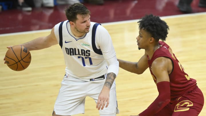 Feb 27, 2024; Cleveland, Ohio, USA; Cleveland Cavaliers forward Isaac Okoro (35) defends Dallas Mavericks guard Luka Doncic (77) in the fourth quarter at Rocket Mortgage FieldHouse. Mandatory Credit: David Richard-USA TODAY Sports