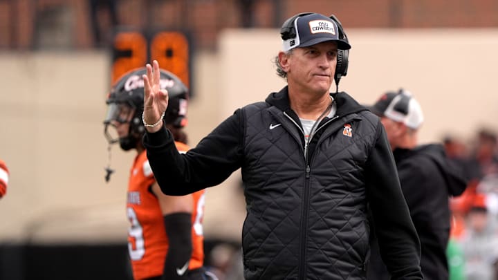 Oklahoma State interim head coach Doug Meacham signals on the sidelines in the first half of the college football game between the Oklahoma State Cowboys and the Iowa State Cyclones at Boone Pickens Stadium in Stillwater, Oklahoma. Oklahoma State interim head coach Doug Meacham signals on the sidelines in the first half of the college football game between the Oklahoma State Cowboys and the Iowa State Cyclones at Boone Pickens Stadium in Stillwater, Oklahoma.