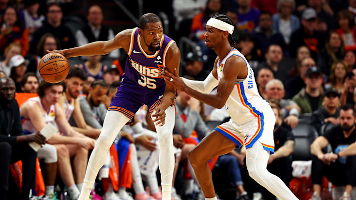 Mar 3, 2024; Phoenix, Arizona, USA; Phoenix Suns forward Kevin Durant (35) handles the ball against Oklahoma City Thunder guard Shai Gilgeous-Alexander (2) during the second quarter at Footprint Center. Mandatory Credit: Mark J. Rebilas-Imagn Images