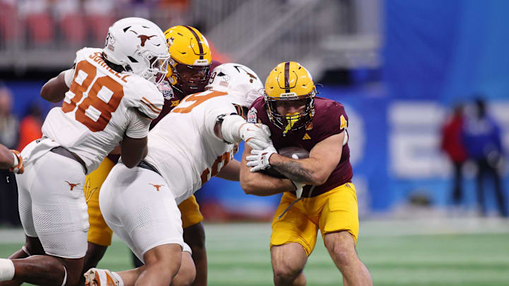 Jan 1, 2025; Atlanta, GA, USA; Arizona State Sun Devils running back Cam Skattebo (4) runs with the ball against Texas Longhorns defensive lineman Jermayne Lole (99) during the first half of the Peach Bowl at Mercedes-Benz Stadium. Mandatory Credit: Brett Davis-Imagn Images