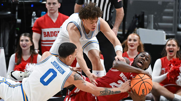 Mar 14, 2025; Indianapolis, IN, USA; UCLA Bruins guard Kobe Johnson (0), UCLA Bruins guard Trent Perry (1) and Wisconsin Badgers guard John Blackwell (25) go for a loose ball during the second half at Gainbridge Fieldhouse.
