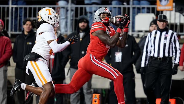 Ohio State Buckeyes wide receiver Jeremiah Smith (4) catches a touchdown pass in front of Tennessee Volunteers defensive back Jermod McCoy (3) during the second half of the College Football Playoff first round game at Ohio Stadium in Columbus on Dec. 22, 2024. Ohio State won 42-17.