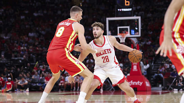 Oct 6, 2025; Houston, Texas, USA; Houston Rockets center Alperen Sengun (28) controls the ball as Atlanta Hawks forward/center Kristaps Porzingis (8) defends during the second quarter at Toyota Center. Mandatory Credit: Troy Taormina-Imagn Images
