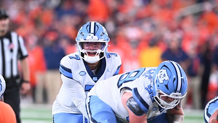 Oct 31, 2025; Syracuse, New York, USA; North Carolina Tar Heels quarterback Gio Lopez (7) with center Austin Blaske (58) at the line of scrimmage in the third quarter against the Syracuse Orange at the JMA Wireless Dome. Mandatory Credit: Mark Konezny-Imagn Images