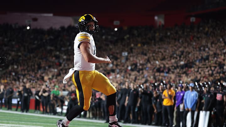 Sep 19, 2025; Piscataway, New Jersey, USA; Iowa Hawkeyes quarterback Mark Gronowski (11) scores a rushing touchdown during the first half against the Rutgers Scarlet Knights at SHI Stadium. Mandatory Credit: Vincent Carchietta-Imagn Images