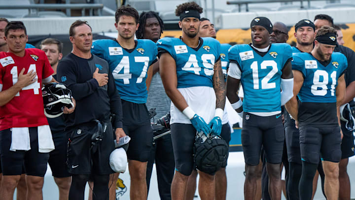 Jacksonville Jaguars quarterback Nick Mullens (14), Jacksonville Jaguars defensive coordinator Anthony Campanile, left, Jacksonville Jaguars tight end Patrick Herbert (47), tight end Shawn Bowman (49) and Travis Hunter (12) and tight end Austin Trammell (81)stand on the sideline during the National Anthem before an NFL scrimmage at EverBank Stadium Friday August 1, 2025, in Jacksonville, Fla. [Doug Engle/Florida Times-Union]