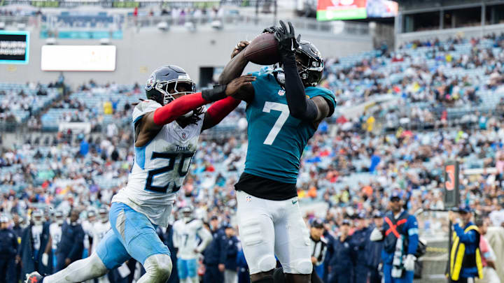 Dec 29, 2024; Jacksonville, Florida, USA; Jacksonville Jaguars wide receiver Brian Thomas Jr (7) catches the ball for a touchdown against Tennessee Titans cornerback Jarvis Brownlee Jr. (29) in the fourth quarter at EverBank Stadium.