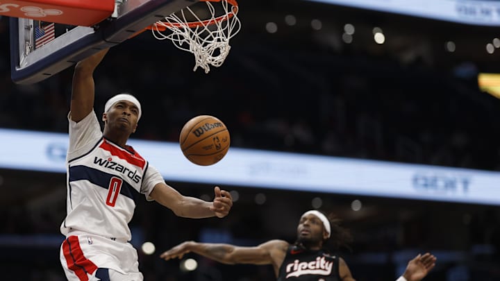 Feb 26, 2025; Washington, District of Columbia, USA; Washington Wizards guard Bilal Coulibaly (0) dunks the ball as Portland Trail Blazers forward Jerami Grant (9) defends in the second half at Capital One Arena. Mandatory Credit: Geoff Burke-Imagn Images