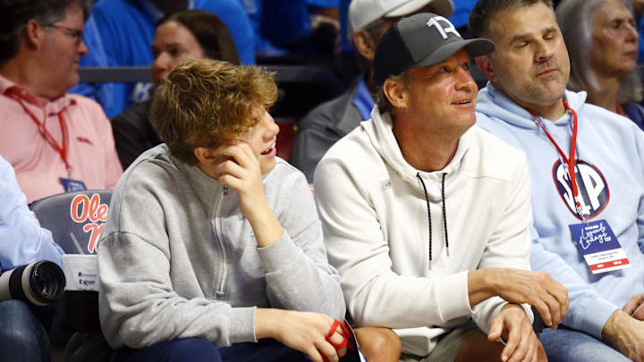 Feb 15, 2025; Oxford, Mississippi, USA; Mississippi Rebels head football coach Lane Kiffin (right) sits court-side with his son Knox Kiffin (left) during the second half between the Mississippi State Bulldogs and the Mississippi Rebels at The Sandy and John Black Pavilion at Ole Miss. Mandatory Credit: Petre Thomas-Imagn Images