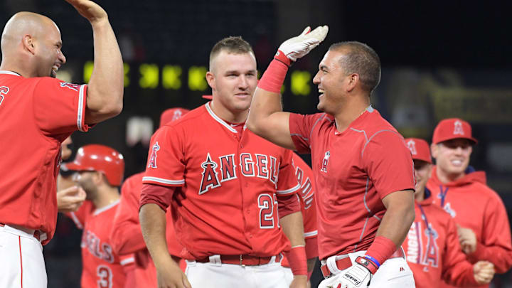 Apr 11, 2017; Anaheim, CA, USA; Los Angeles Angels catcher Carlos Perez (right) celebrates with designated hitter Albert Pujols (5) and center fielder Mike Trout (27) after hitting a walk-off bunt in the 10th inning to defeat the Texas Rangers at Angel Stadium of Anaheim. The Angels won 6-5 in 10 innings. Mandatory Credit: Kirby Lee-Imagn Images